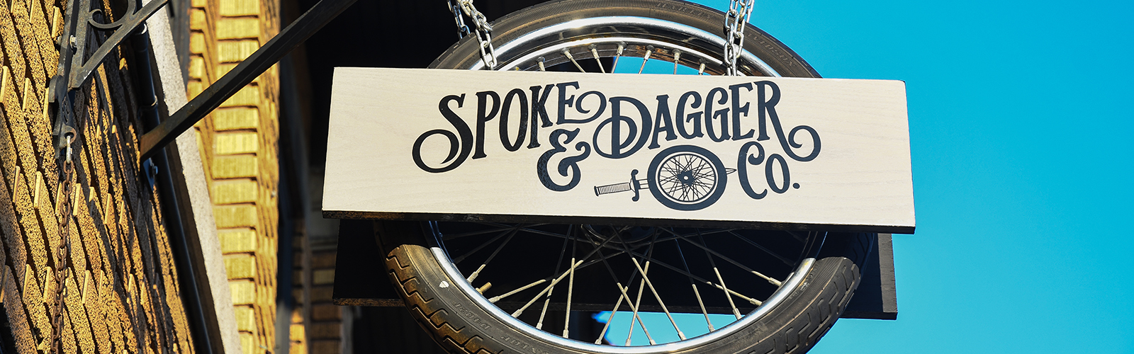Spoke & Dagger Co., located at 1434 Hertel Ave., Buffalo, is identifiable by its swinging tire sign.