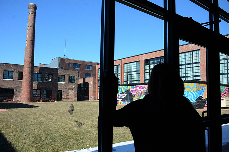 Lindsey Marvin looks out on the courtyard of the building where Barrel + Brine is operated. A summer event is being planned by the businesses in the complex.
