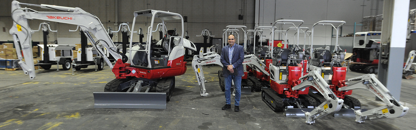 Green Machine CEO Jon Williams with a fleet of Takeuchi excavators that will be retrofitted with Green Machine batteries, which provide clean power and can run for seven hours before needing a recharge.