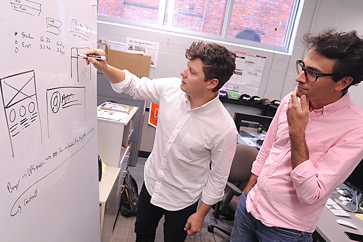 Helm founders Nicholas Barone and Jonathan Gorczyca use their idea board as they discuss their latest project.