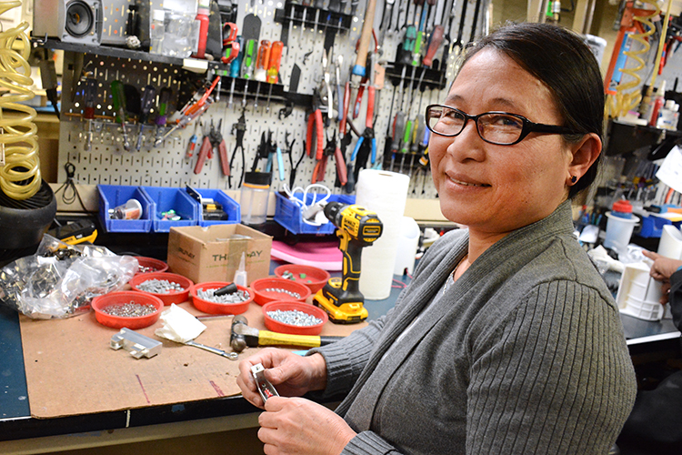 Litelab employee Julia Bu, formerly of Myanmar, assembles a light fitting at the downtown Buffalo facility. 