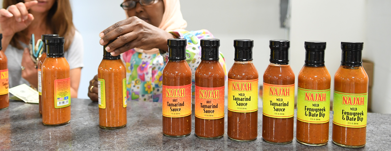 The Najah savory sauce line: owner Bisharo Ali shows product to a new customer 