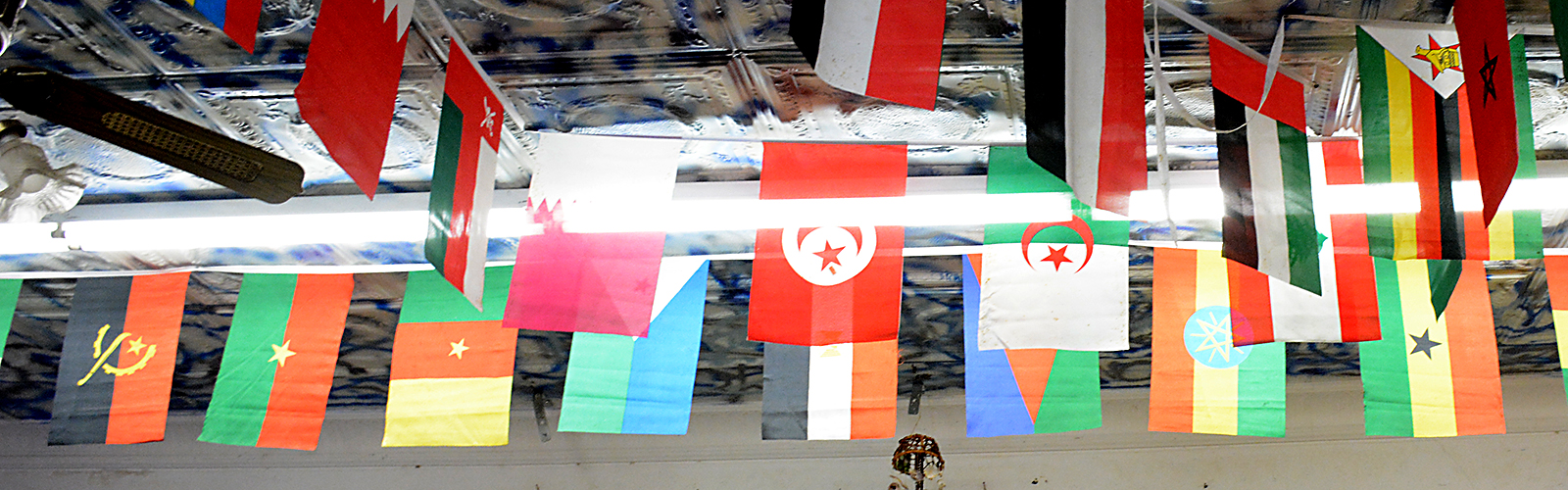 International flags displayed on the ceiling of Yasin Market.