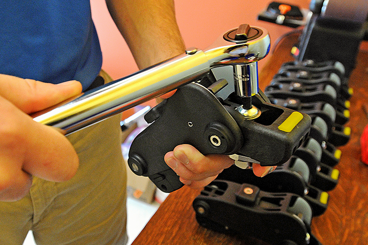 LegWorks co-founder Brandon Burke uses a torque wrench to adjust a prosthetic knee joint.