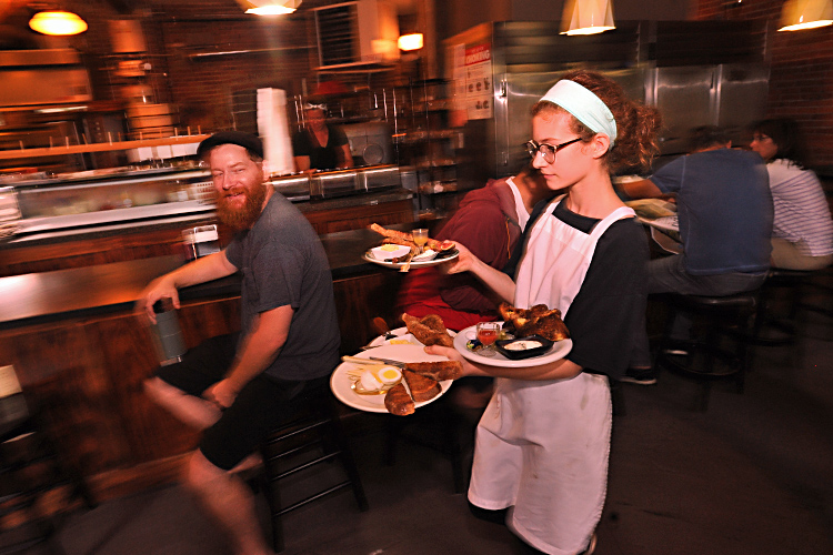 Five Points Bakery owner Kevin Gardner gives his daughter, Molly, a smile as she carries out an order at the popular Westside eatery.