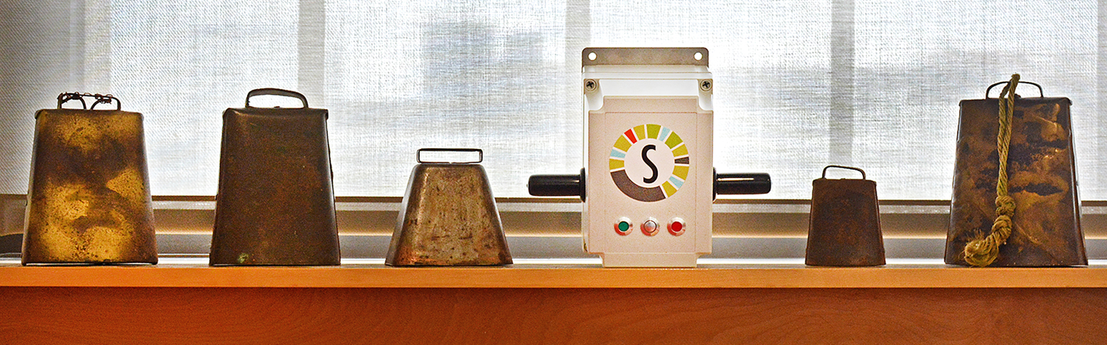 The SomaDetect’s sensor, framed by a collection of vintage cow bells given to the company by area farmers who use their technology to produce better milk.