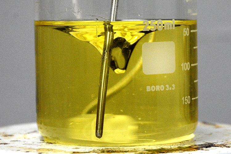 Checking the temperature as the magnetic stirrer blends the CBD with a carrier oil, which makes the final product consumable.