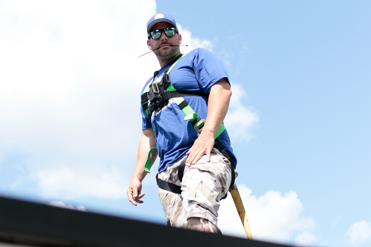 Tyler Uebelhoer of Buffalo Solar Solutions at work on a roof mount installation in Williamsville, New York. The job included a  total of 63 solar panels. 