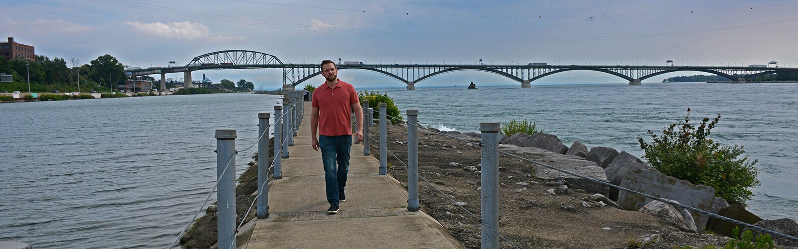 Dr. Aaron Krolikowski, co-founder of Cazenovia West, walks the breakwall between the Niagara River and the Black Rock Canal. 