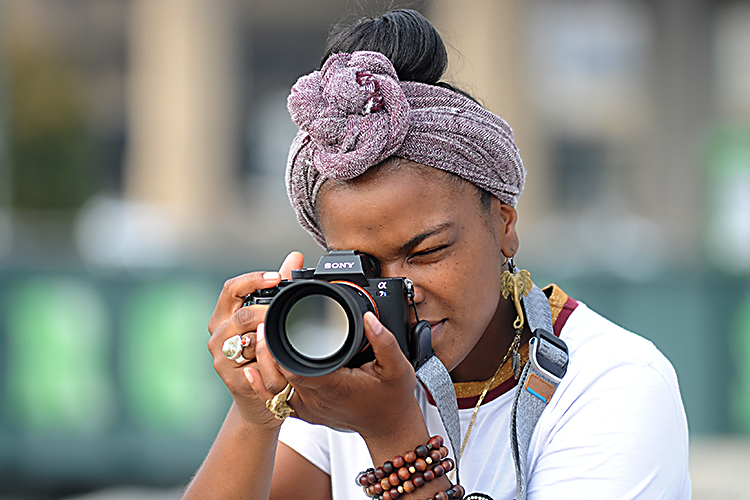 Aitina Fareed-Cooke, a CEPA Gallery Award-winning photographer and owner of Get Fokus'd Productions, shoots with her Sony mirrorless digital camera at Canalside. 