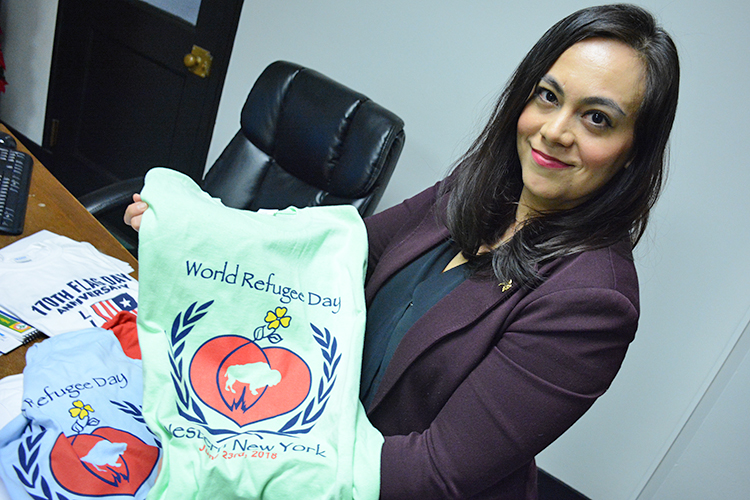 Jessica Lazarin, director of the Office of New Americans, shows off a T-shirt from last year’s World Refugee day, which was on June 23. 