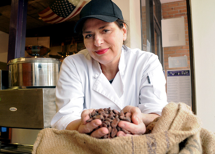 Joanne Sundell, the owner of Dark Forest Chocolate Makers, holds cocoa beans that she uses to make her candy bars.