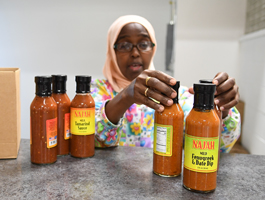 The Najah savory sauce line: owner Bisharo Ali shows product to a new customer 