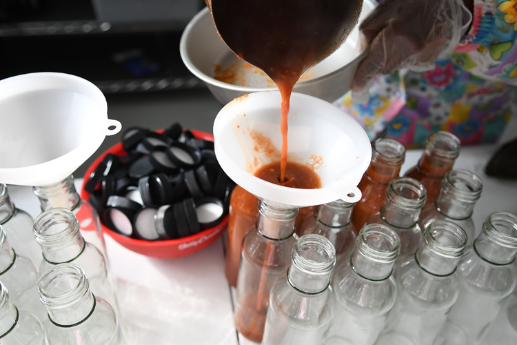 Bisharo Ali bottling her savory fenugreek date dip.