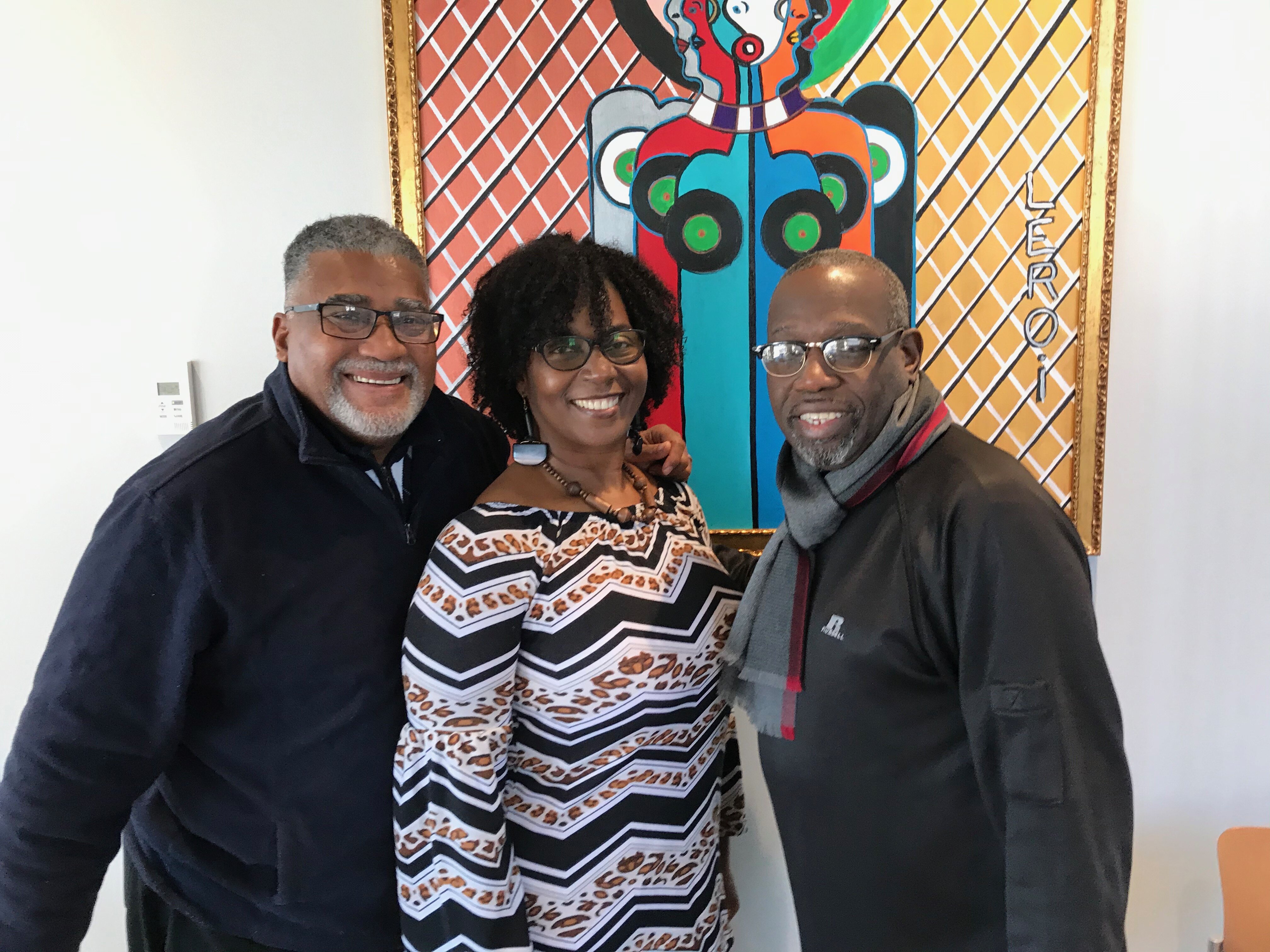 Dale Holt, Tina Grant-Holt and Reginald Ingram, in front of a lively painting by local artist LeRoi Johnson