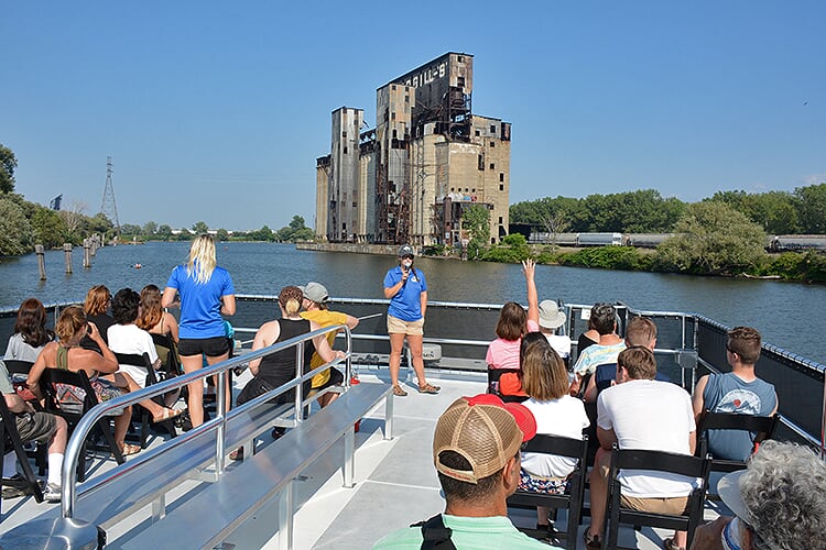 Buffalo River History Tours docent Siobhan Clements gives passengers a history lesson on The Cargills grain elevator, which was built in the 1920s and previously named the Saskatchewan Cooperative Elevator. 