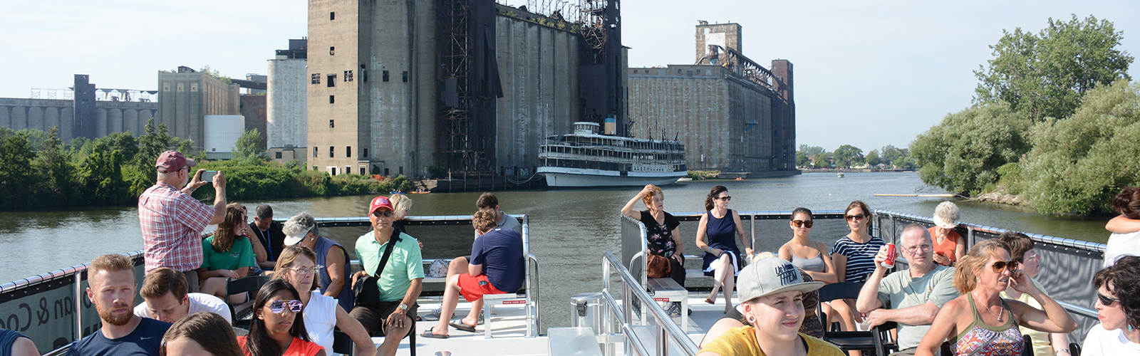 Buffalo River History Tours passengers learn about the SS Columbia, which is docked in the Buffalo River next to the historic grain elevators at Silo City.