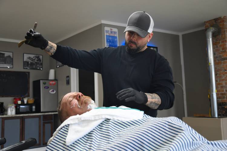 Ronny Rocklin prepares a shave for his first customer of the afternoon, Ken Margarucci.