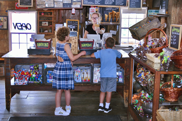 Sweet Jenny’s employee Katie Nebbia serves up ice cream to a pair of enthusiastic patrons.