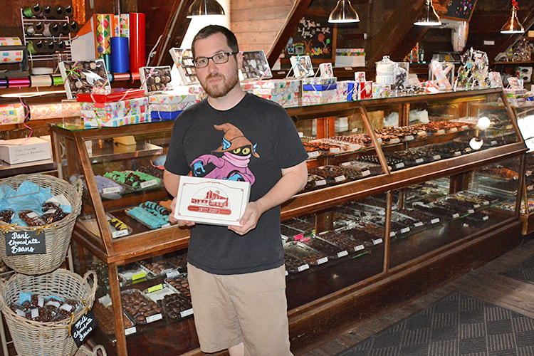 Sweet Jenny’s owner Howard Cadmus with a gift box of chocolates that is available at his shop at 56 East Spring St. in Williamsville.